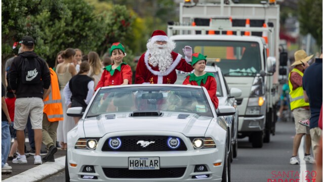 Image © Claude Thérond – used with permission Santa and elves riding in a white Mustang at the 2023 Pohutukawa Coast Santa Parade.