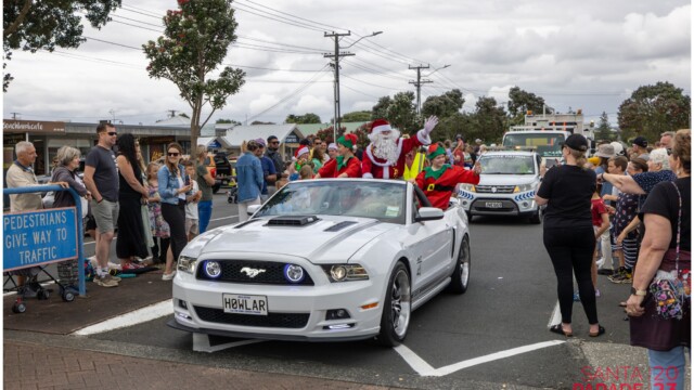 Image © Claude Thérond – used with permission Santa waving from a white Mustang at the 2023 Pohutukawa Coast Santa Parade.